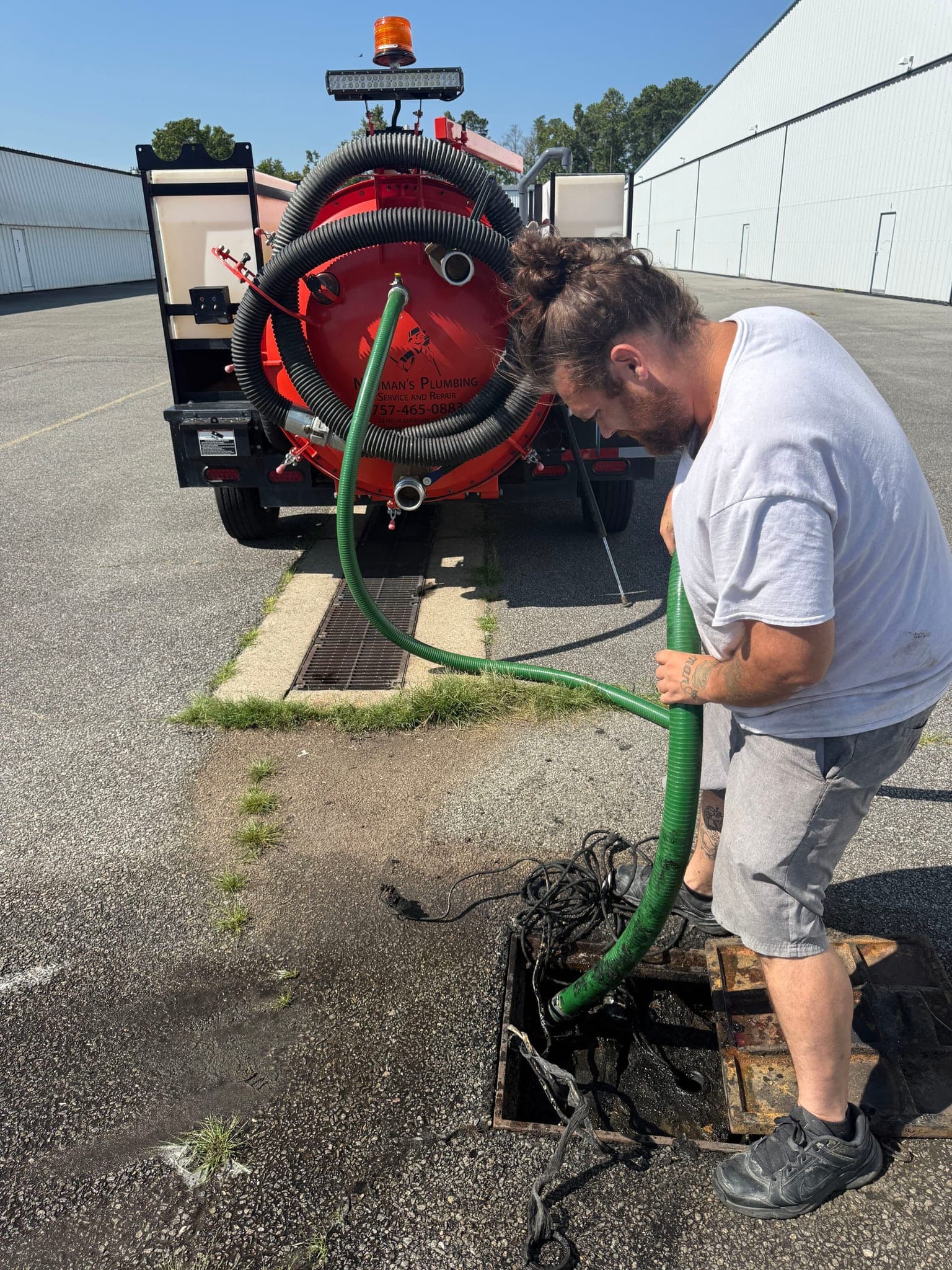 Newman's Plumbing technician pumping out a commercial grease trap with the vacuum truck in Portsmouth, VA