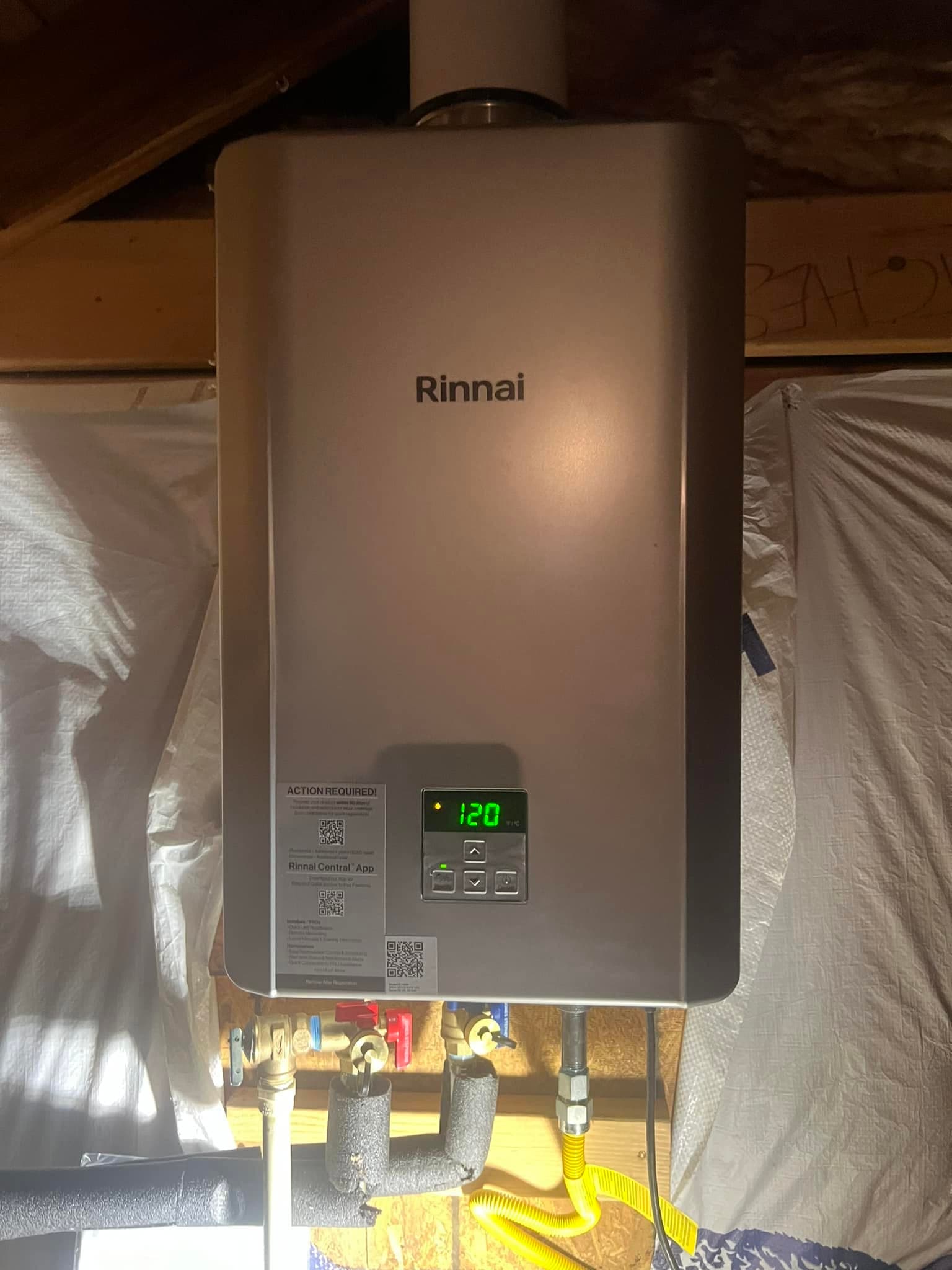 Newman's Plumbing technician servicing a wall-mounted Rinnai unit in a Portsmouth VA utility closet — Newman's Plumbing Service & Repair
